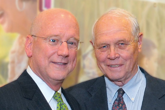 Glenn Biggs, (right), first chairman of the Health Science Center Development Board, celebrates the NCI-CTRC designation with President Henrich.