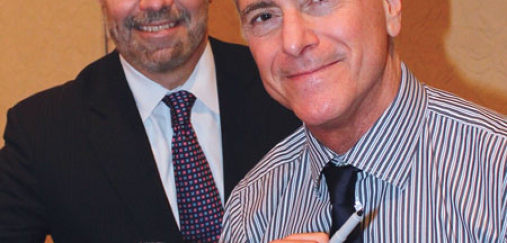 Author A. Scott Berg (right) signs his book "Wilson," for Francisco González-Scarano, M.D., dean of the Long School of Medicine.