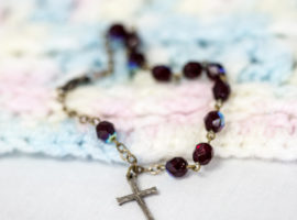 Small rosary on a baby blanket