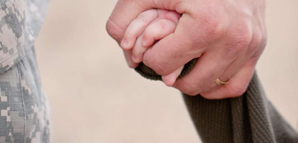 soldier holding kid's hand.