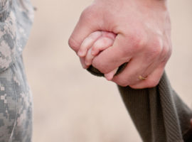 soldier holding kid's hand.