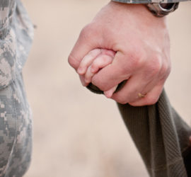 soldier holding kid's hand.