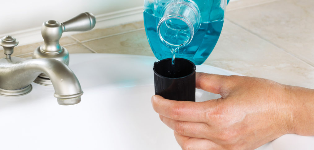 person pouring mouthwash into cup