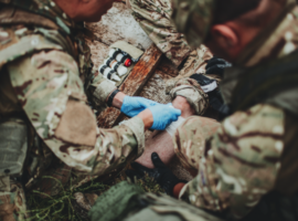 stock image of military medics treating trauma patient.