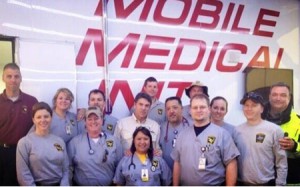 Several responders from the Texas Emergency Medical Task Force, including two from the UT Health Science Center, visit with Gov. Rick Perry in West following the fire and explosion at the fertilizer plant. Emily Kidd, M.D., is on the first row on the left and Todd Bergbacher, D.O., is third from the left in the back row next to Gov. Perry, who is wearing the tan shirt.