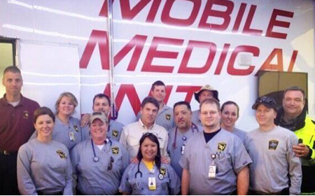 Several responders from the Texas Emergency Medical Task Force, including two from the UT Health Science Center, visit with Gov. Rick Perry in West following the fire and explosion at the fertilizer plant. Emily Kidd, M.D., is on the first row on the left and Todd Bergbacher, D.O., is third from the left in the back row next to Gov. Perry, who is wearing the tan shirt.