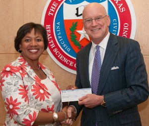 Michelle A. Thomas, assistant vice president of External Affairs for AT&T Service Inc., presents Wiliam L. Henrich, M.D., MACP, Health Science Center president, with the final installment of $5 million gift to the university.