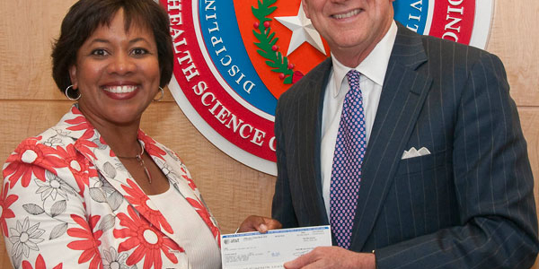 Michelle A. Thomas, assistant vice president of External Affairs for AT&T Service Inc., presents Wiliam L. Henrich, M.D., MACP, Health Science Center president, with the final installment of $5 million gift to the university.