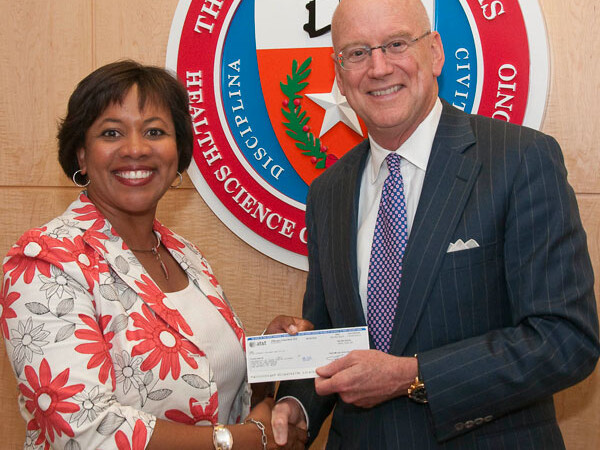 Michelle A. Thomas, assistant vice president of External Affairs for AT&T Service Inc., presents Wiliam L. Henrich, M.D., MACP, Health Science Center president, with the final installment of $5 million gift to the university.