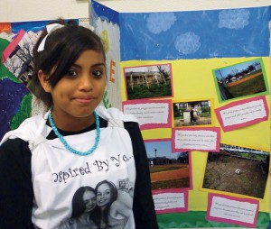 Ebany Espinoza, a Girl Scout and eighth grader at Tafolla Middle School in the San Antonio Independent School District, proudly displays her “Photovoice” project, which is contributing to research undertaken by the Institute for Health Promotion Research at the UT Health Science Center San Antonio.