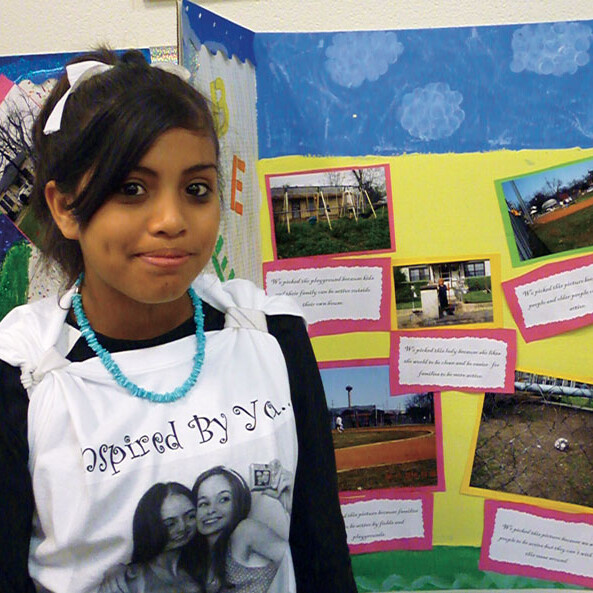 Ebany Espinoza, a Girl Scout and eighth grader at Tafolla Middle School in the San Antonio Independent School District, proudly displays her “Photovoice” project, which is contributing to research undertaken by the Institute for Health Promotion Research at the UT Health Science Center San Antonio.