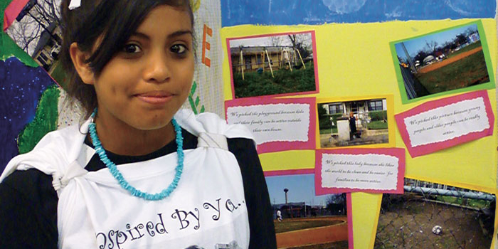 Ebany Espinoza, a Girl Scout and eighth grader at Tafolla Middle School in the San Antonio Independent School District, proudly displays her “Photovoice” project, which is contributing to research undertaken by the Institute for Health Promotion Research at the UT Health Science Center San Antonio.