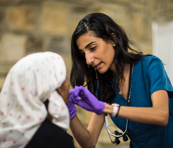 Fourth-year dentistry student Peggah Hammat examines Nar Kami, from Bhutan, at the Refugee Health Clinic.