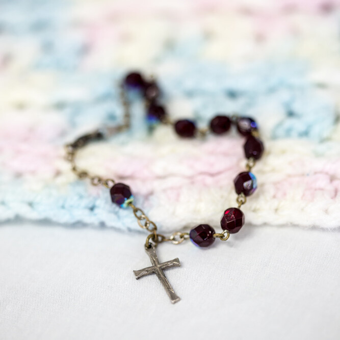 Small rosary on a baby blanket