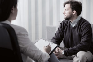 patient suffering from PTSD talking to therapist