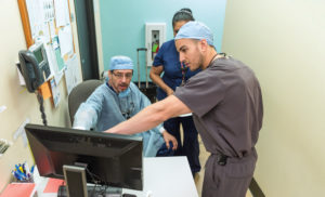 Vidal Balderas, D.D.S., M.P.H., consults with Mohamed Fouad Imam, D.D.S., at San Antonio Christian Dental Clinic.