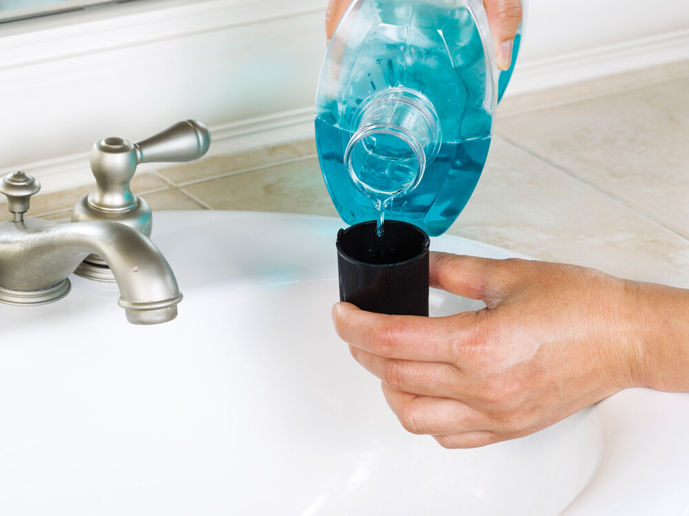 person pouring mouthwash into cup