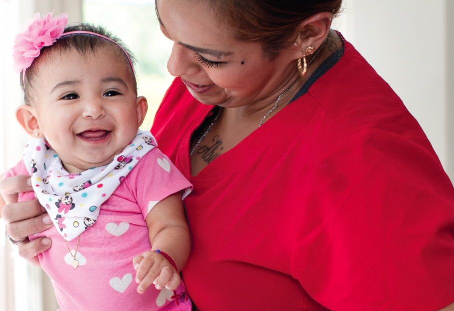 A mother holds a smiling baby