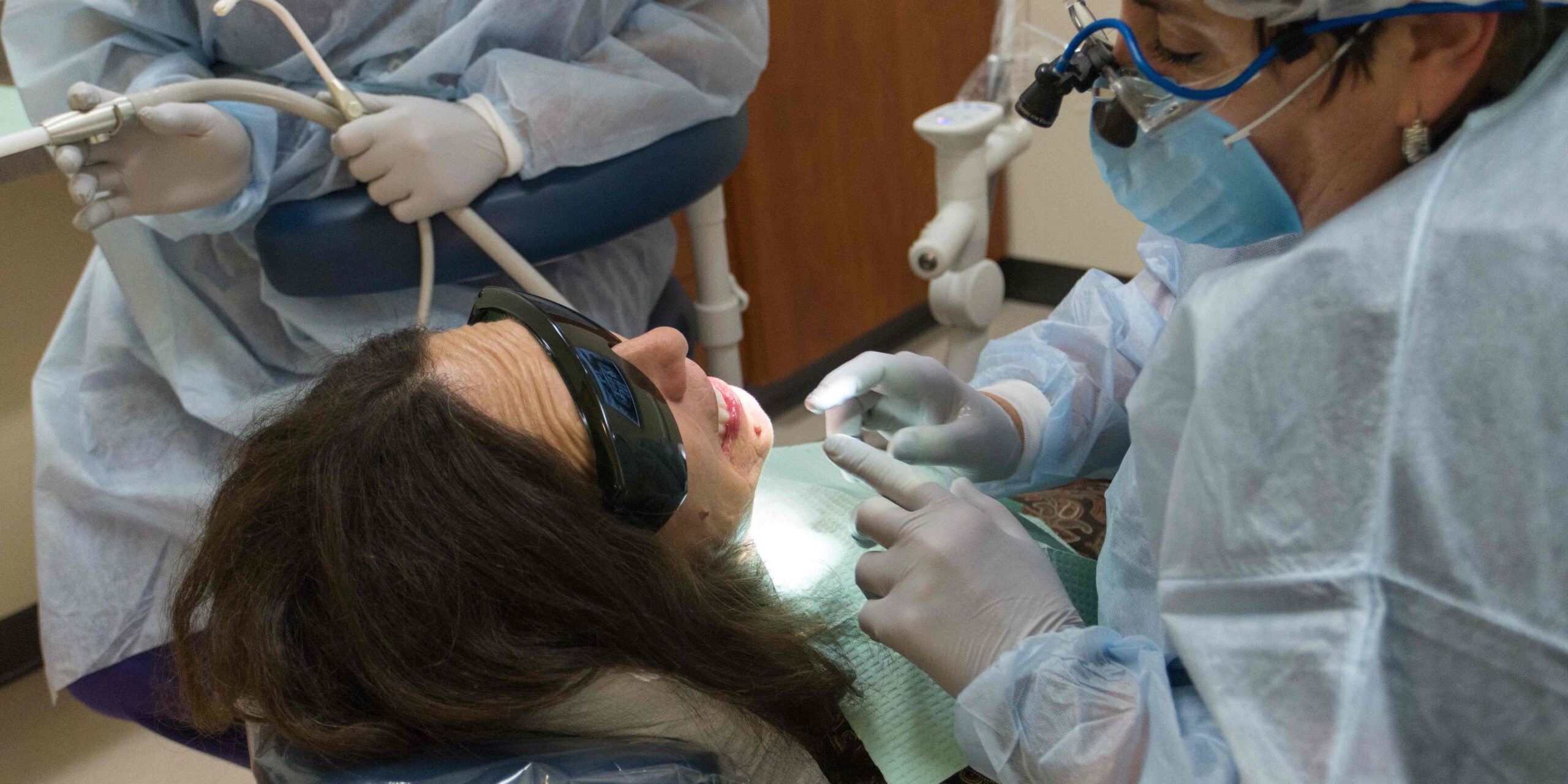 Photo of woman laying in dental chair receiving care