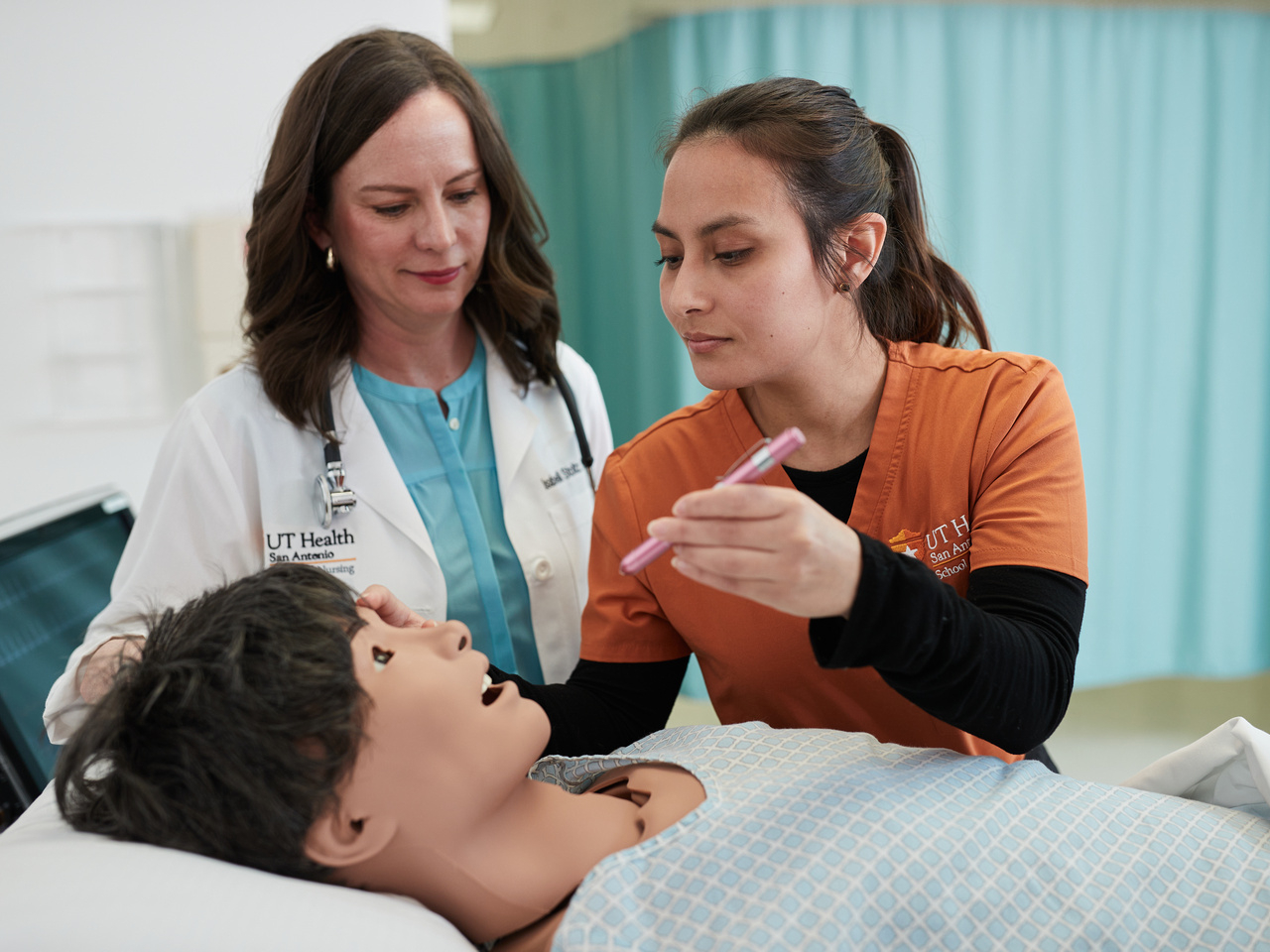 Nurse student practices checking vitals on manikin