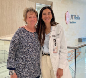 Patient and provider hug and smile in the hospital lobby.