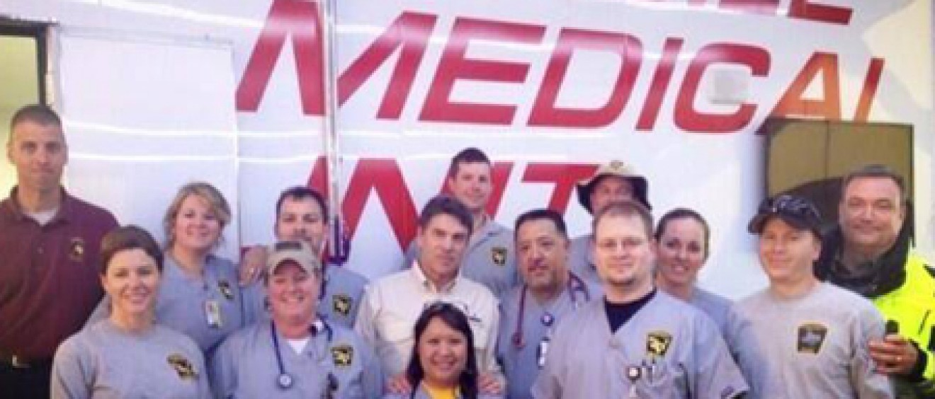 Several responders from the Texas Emergency Medical Task Force, including two from the UT Health Science Center, visit with Gov. Rick Perry in West following the fire and explosion at the fertilizer plant. Emily Kidd, M.D., is on the first row on the left and Todd Bergbacher, D.O., is third from the left in the back row next to Gov. Perry, who is wearing the tan shirt.