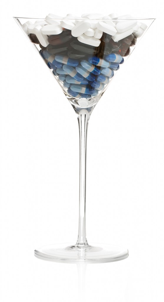 cocktail glass filled with various pills.