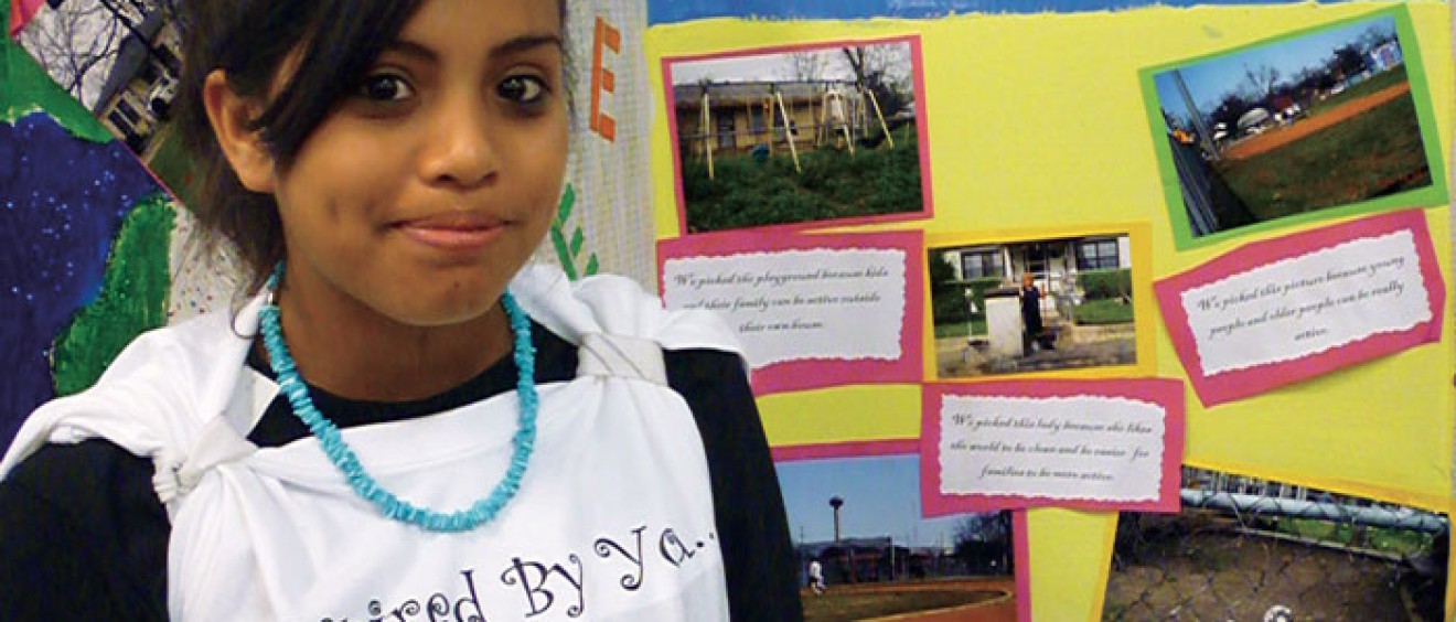Ebany Espinoza, a Girl Scout and eighth grader at Tafolla Middle School in the San Antonio Independent School District, proudly displays her “Photovoice” project, which is contributing to research undertaken by the Institute for Health Promotion Research at the UT Health Science Center San Antonio.