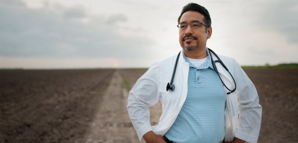 Joel Torres, M.D., stands on a dirt road in the Rio Grande Valley.