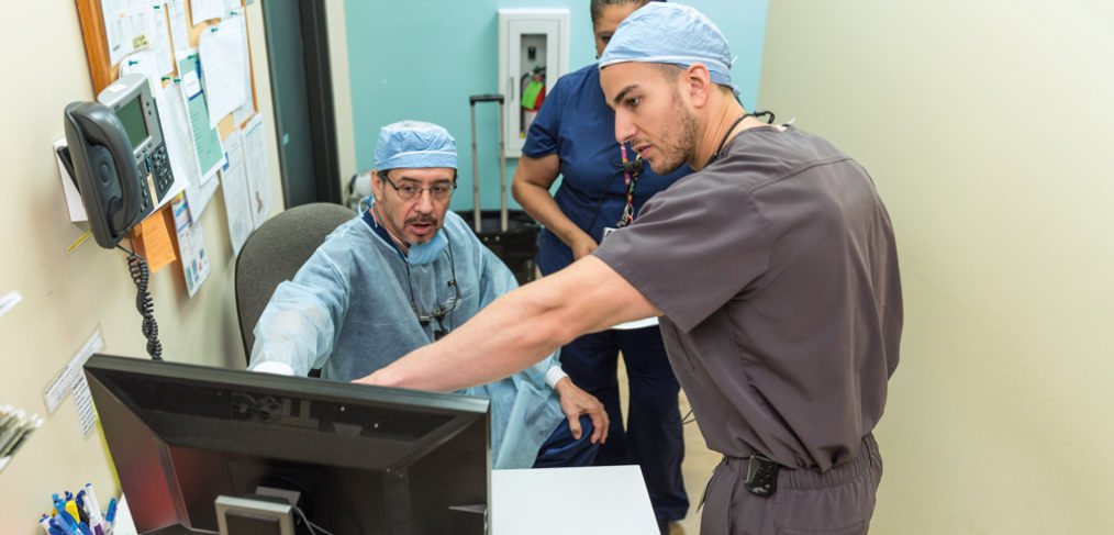 Vidal Balderas, D.D.S., M.P.H., consults with Mohamed Fouad Imam, D.D.S., at San Antonio Christian Dental Clinic.
