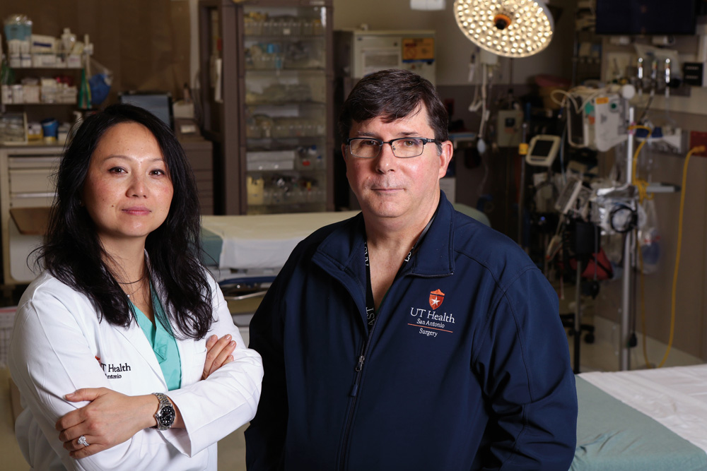 Trauma surgeons Lillian Liao, M.D., M.P.H. ’04, and Ronald Stewart, M.D. ’85, in an operating room