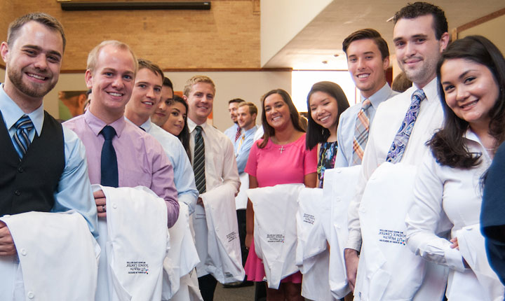 Some of the 100 dental students are shown with their white coats before the first coat initiation ceremony.