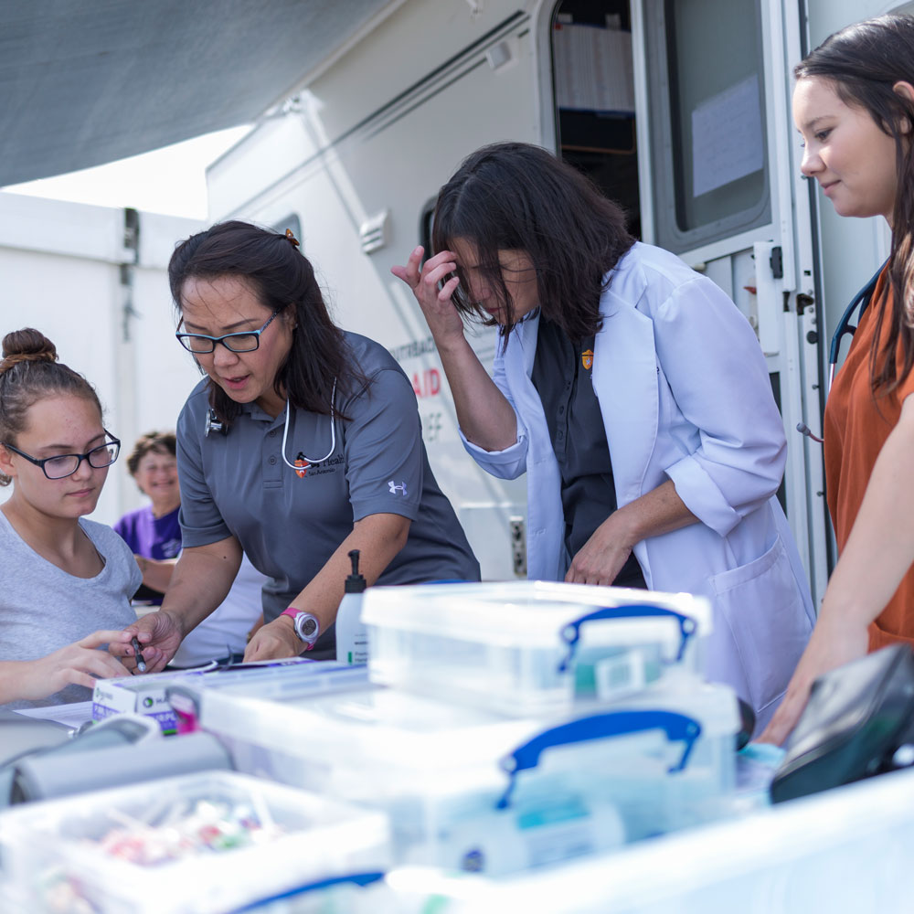 Four nursing students help at mobile clinic
