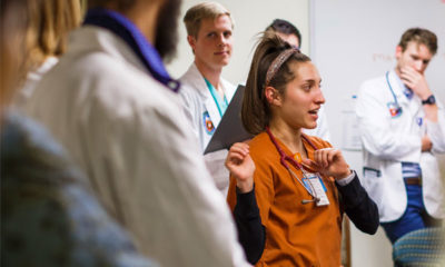 Nursing student Taylor Dramberger discusses a patient’s case with nursing and medical students, including Andrew Jeffery who is behind her to the left, during a faculty-led presentation before the weekly clinic opens to patients.