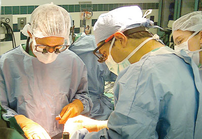 Dr. Glenn Halff (left) and Dr. Francisco Cigarroa perform transplant surgery at University Hospital.