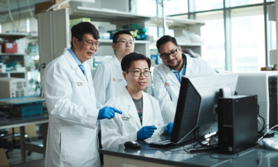 Daohong Zhou, MD, with graduate student Jing Pei and research assistant professors Dongwen Lyu, PhD, MS (seated) and Sajid Khan, PhD, looking at a computer monitor in Zhou's lab.