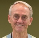 Head shot of a man with grey hair smiling.