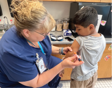 Mize administers an injection to her student patient for his Type 1 diabetes.