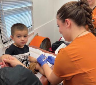 A nursing student provides care to a young child.