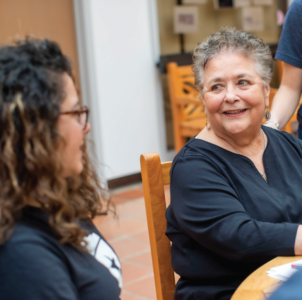 Rogers smiles at a student playing the Saluteria game.
