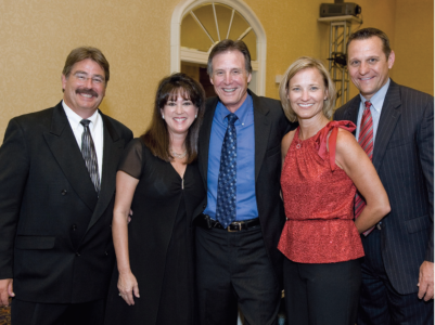 Dr. Gary Guest standing in the middle of a group of friends at a School of Dentistry gala event.