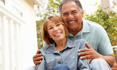 Older hispanic couple hugging one another with smiles.