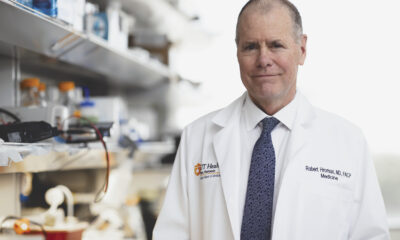 Dr. Robert Hromas poses in a white coat for a picture