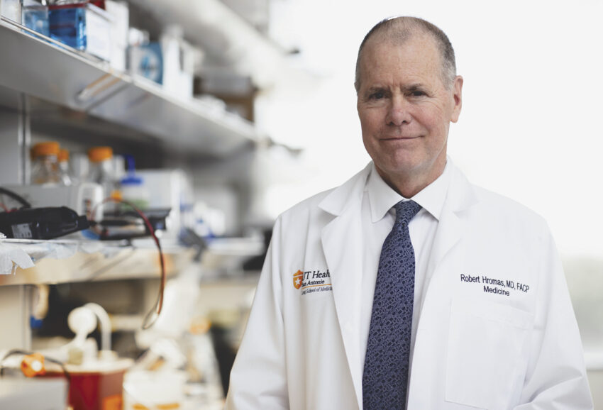 Dr. Robert Hromas poses in a white coat for a picture