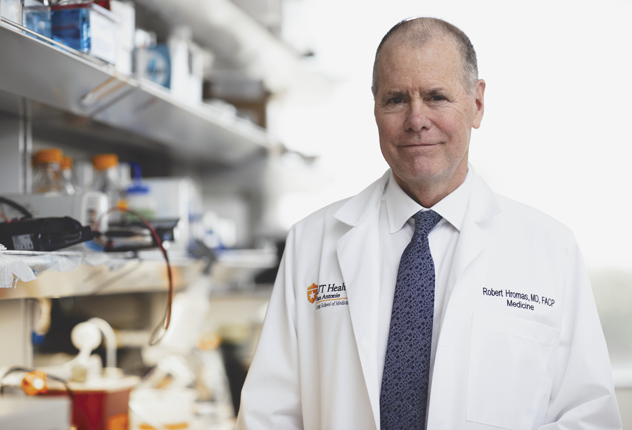 Dr. Robert Hromas poses in a white coat for a picture